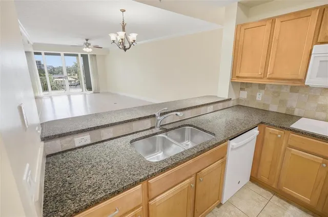 a bathroom with a granite countertop sink and washing machine