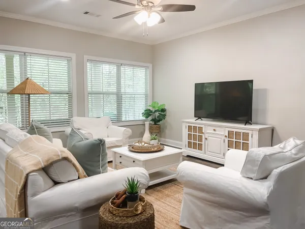 a living room with furniture a flat screen tv and a large window