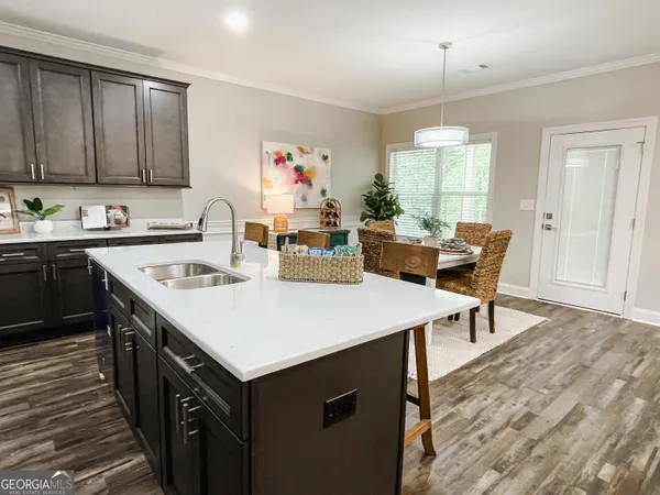 a kitchen with a stove a sink dishwasher and a refrigerator with wooden floor