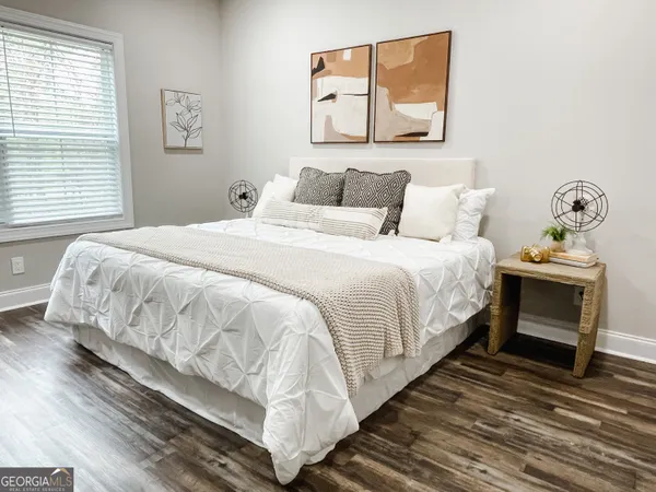 a bedroom with bed and wooden floor