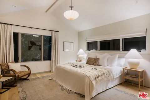 a bedroom with a bed and glass door