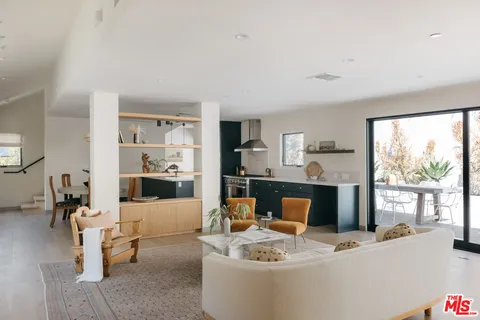 a living room with fireplace furniture and a large window