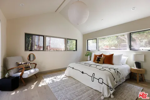 a bedroom with a bed couch and window