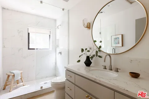 a bathroom with a granite countertop sink mirror and toilet