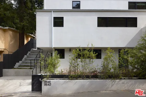 a view of a street with potted plants