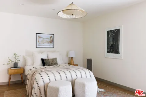 a bedroom with a bed and a painting on the wall