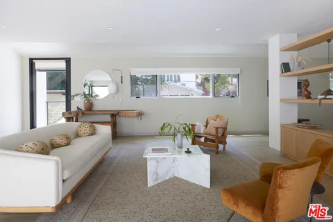 a living room with furniture and painting on the wall
