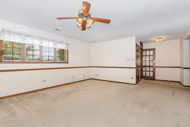 an empty room with fan and windows
