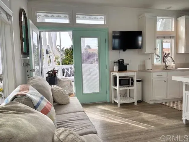 a living room with furniture a flat screen tv and large windows