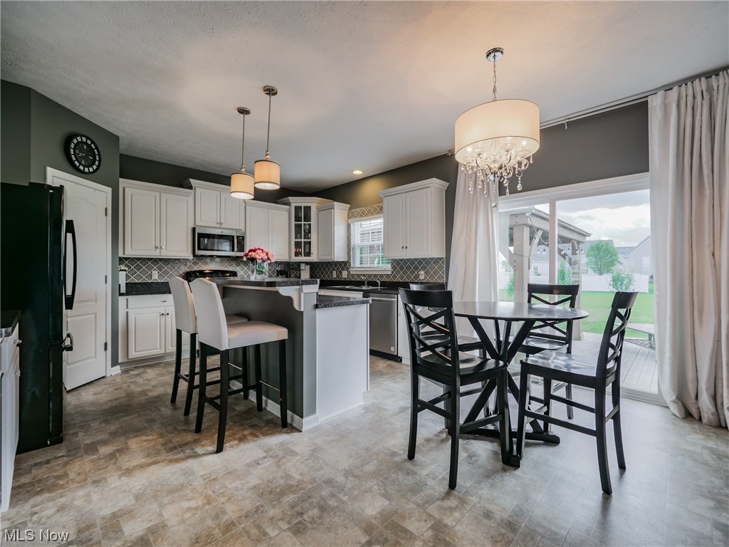 37571 Amber Way North Ridgeville, OH 44039 - Photo 7 of 35 Kitchen with a kitchen island, white cabinets, hanging light fixtures, and an inviting chandelier