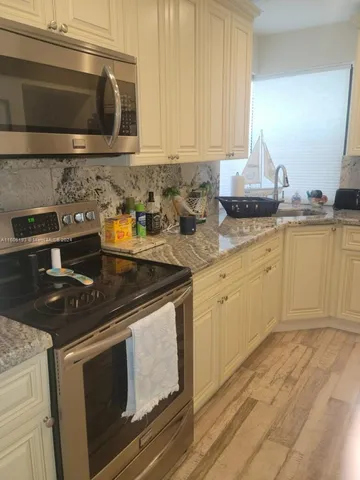 a kitchen with granite countertop a stove and a sink