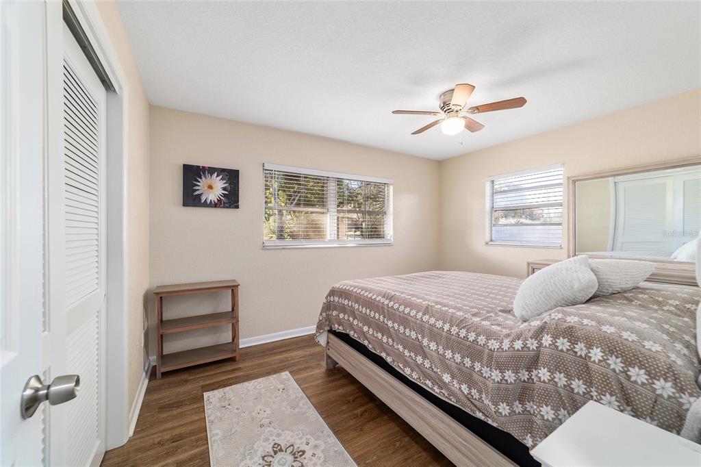 21529 Southwest Honeysuckle Street Dunnellon, FL 34431 - Photo 23 of 55 a bedroom with a large bed and a chandelier
