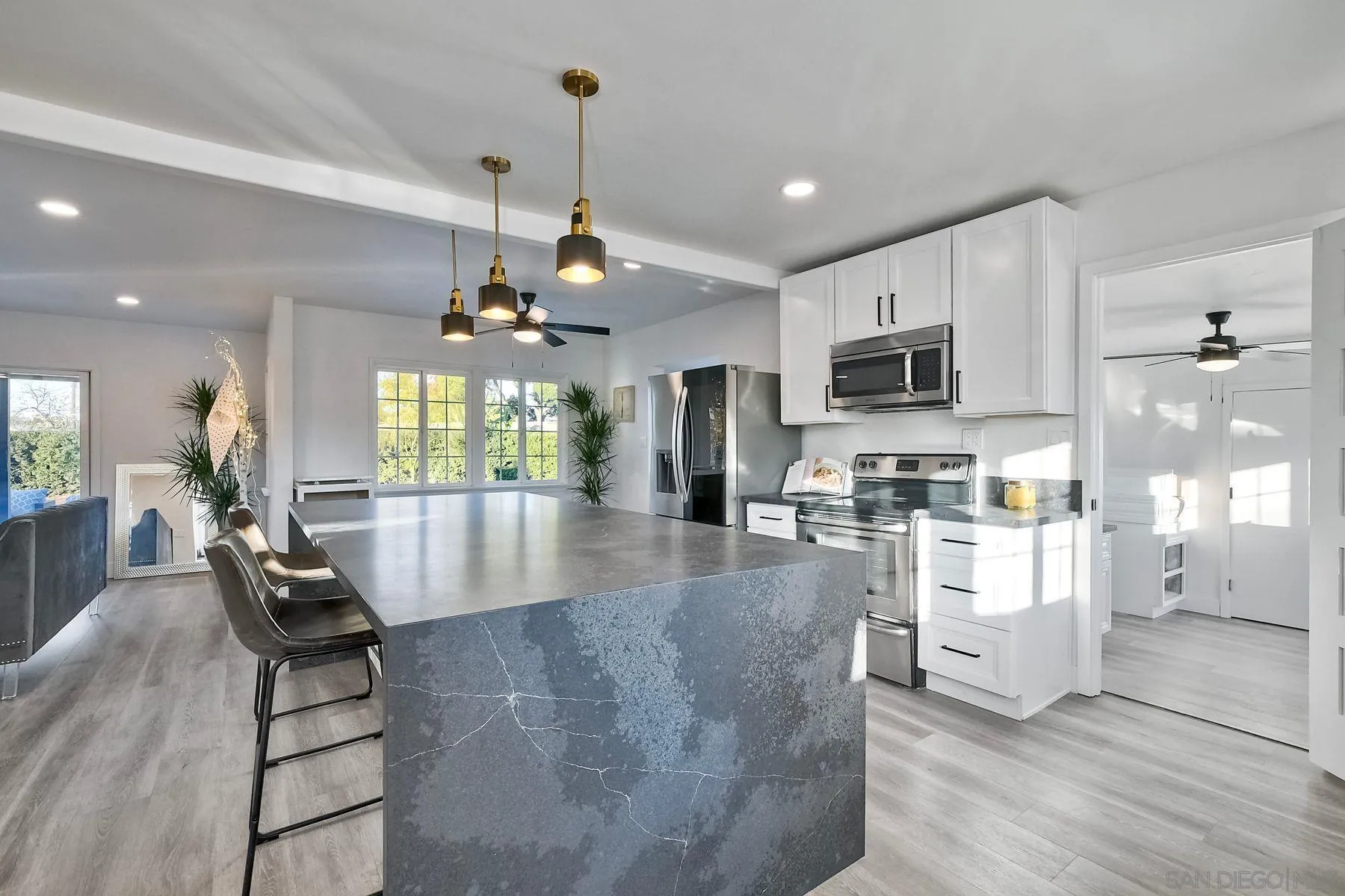 730 Montview Drive Escondido, CA 92025 - Photo 15 of 47 a kitchen with stainless steel appliances kitchen island granite countertop a stove a refrigerator a sink a stove and white cabinets with wooden floor