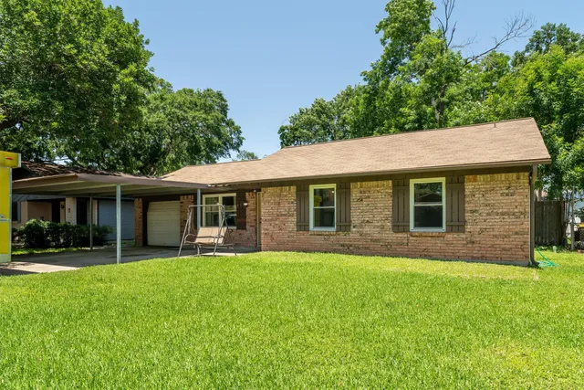 a front view of house with a garden and trees