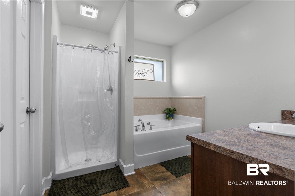 8952 Sherman Road Foley, AL 36535 - Photo 26 of 41 Full bathroom featuring a shower stall, a soaking tub, a vanity with a drop-in sink, and tile flooring