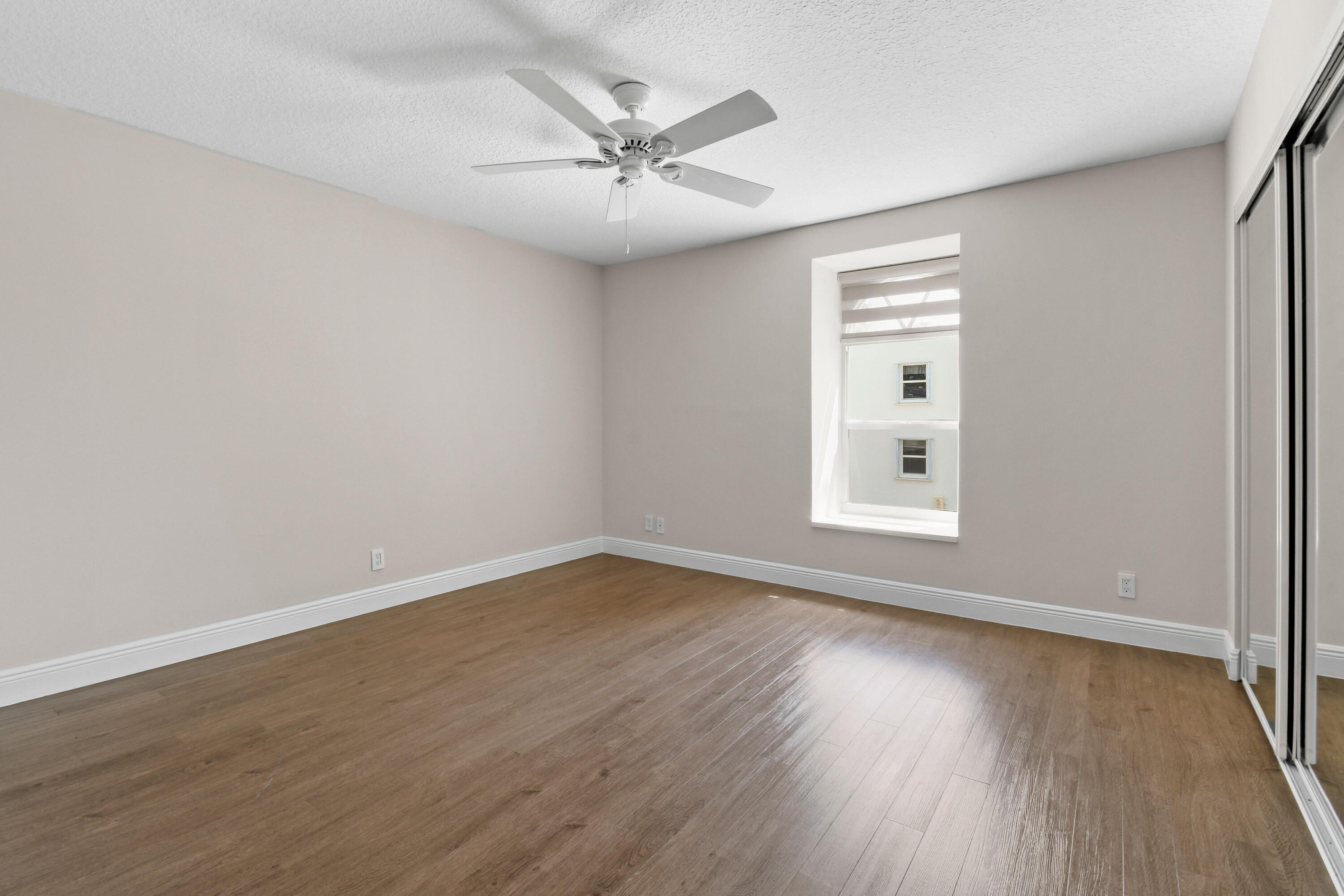 396 Golfview Road, Unit E North Palm Beach, FL 33408 - Photo 13 of 45 wooden floor in an empty room with a window