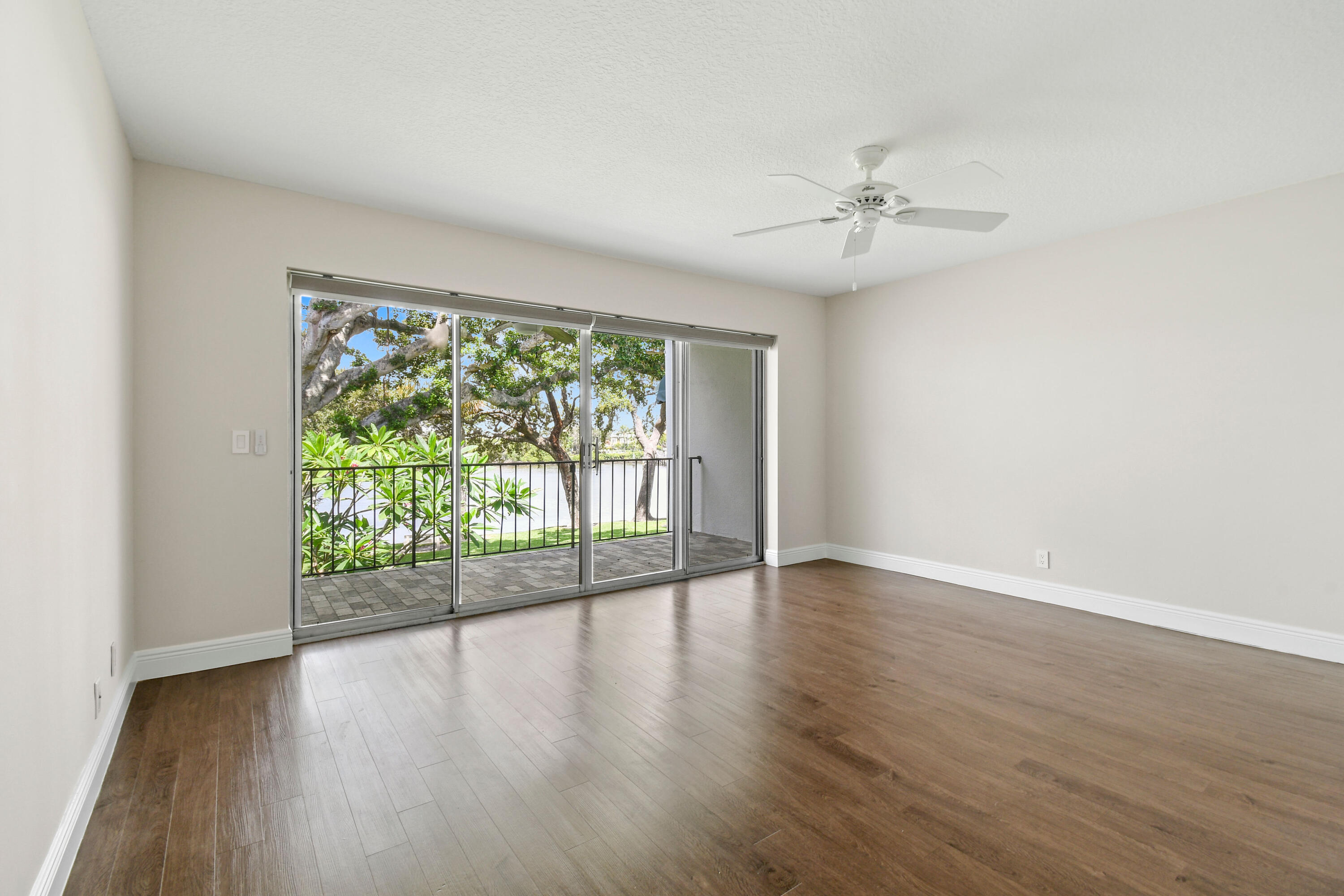396 Golfview Road, Unit E North Palm Beach, FL 33408 - Photo 18 of 45 an empty room with wooden floor and windows