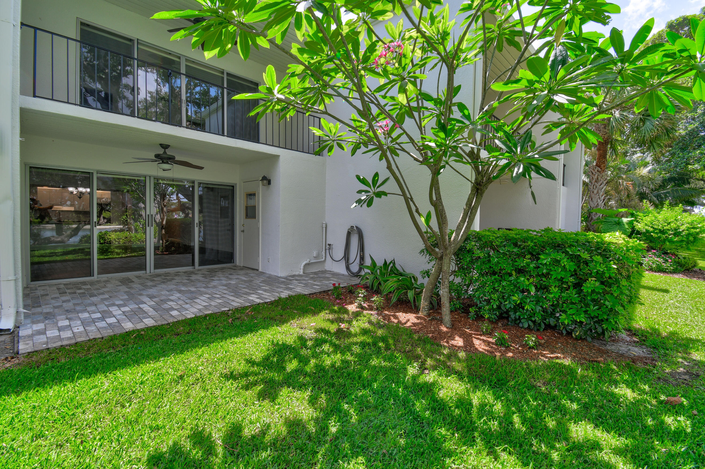 396 Golfview Road, Unit E North Palm Beach, FL 33408 - Photo 26 of 45 a view of a wooden house with a yard and potted plants