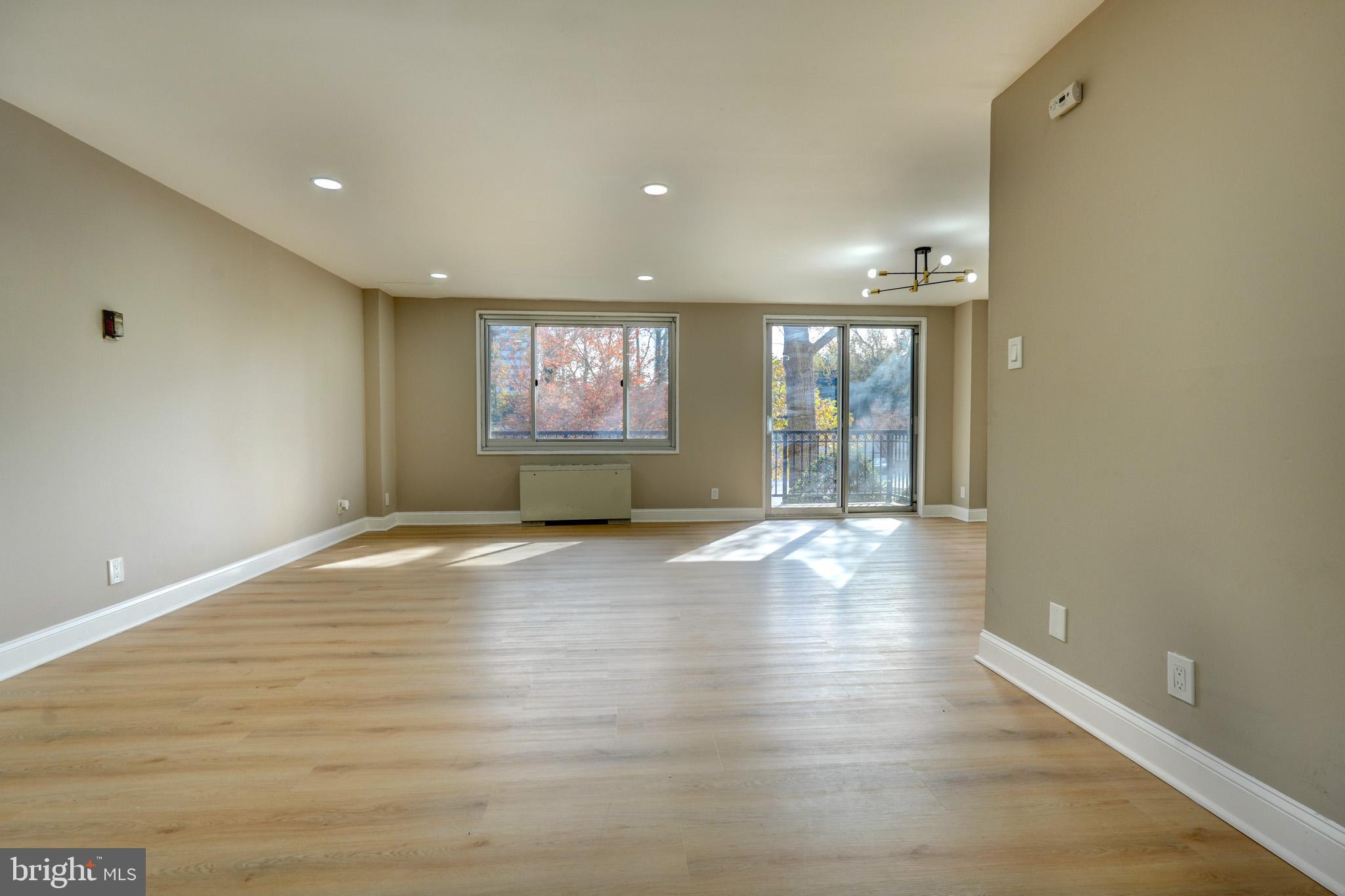 1900 Lyttonsville Road, Unit 211 Silver Spring, MD 20910 - Photo 1 of 46 an empty room with wooden floor and windows