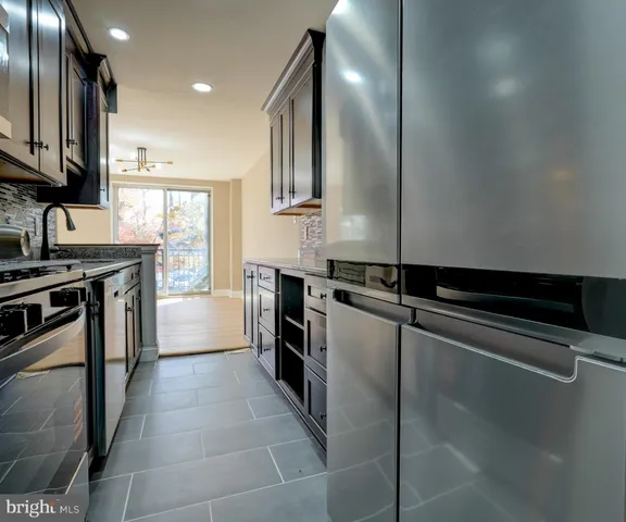a kitchen with stainless steel appliances a sink stove and cabinets