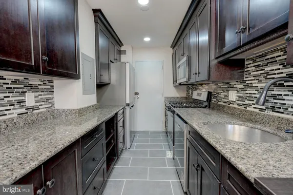 a kitchen with granite countertop stainless steel appliances and wooden cabinets