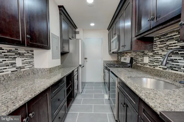 a kitchen with granite countertop stainless steel appliances and wooden cabinets