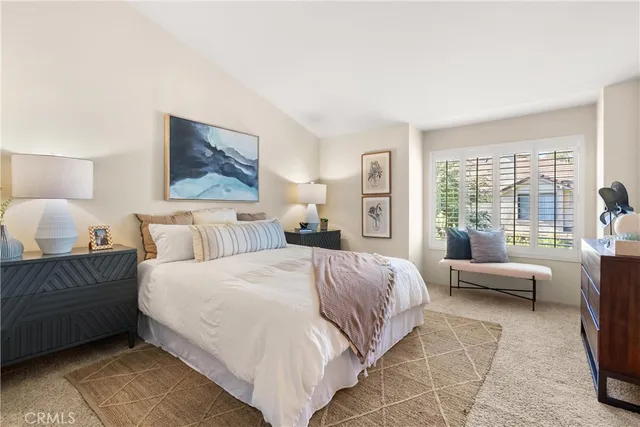 a bedroom with a large bed couch and a large window