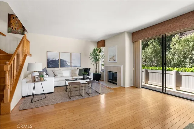 a living room with fireplace furniture and a large window