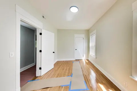 a view of a room with wooden floor and windows