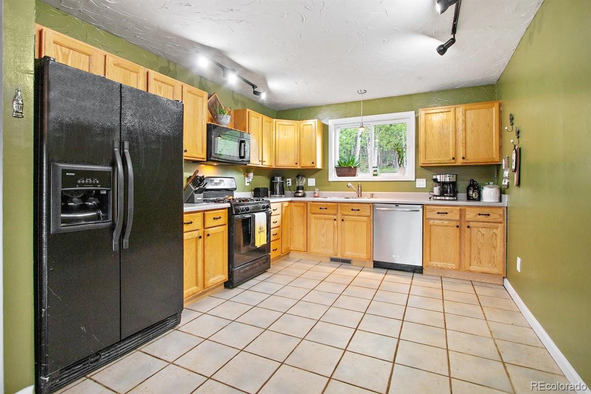 191 Renaud Road Bailey, CO 80421 - Photo 11 of 28 a kitchen with stainless steel appliances granite countertop a stove top oven sink and cabinets