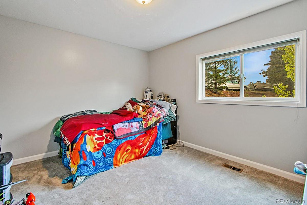 191 Renaud Road Bailey, CO 80421 - Photo 19 of 28 a bedroom with a bed and window