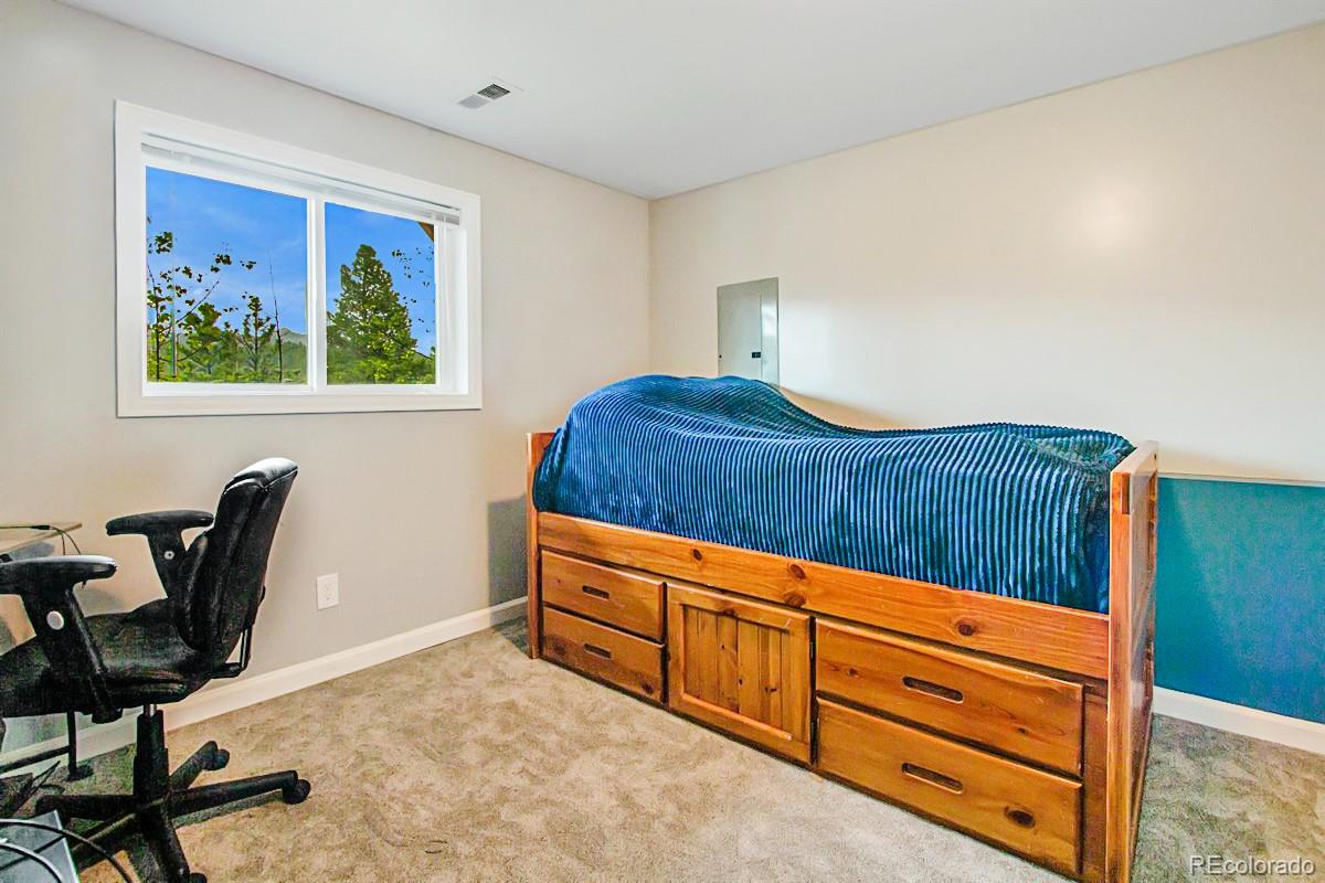 191 Renaud Road Bailey, CO 80421 - Photo 24 of 28 a bedroom with a bed and furniture