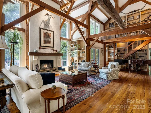 a living room with furniture fireplace and a large window