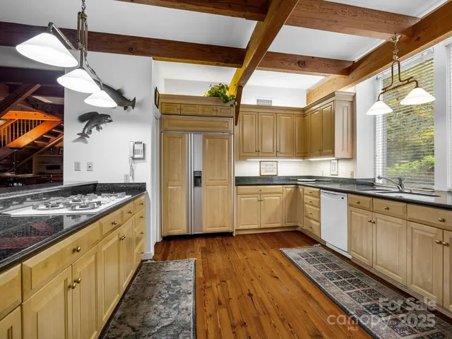 a kitchen with stainless steel appliances granite countertop a stove a sink and a refrigerator