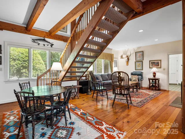 a living room with furniture a rug water chandelier and windows