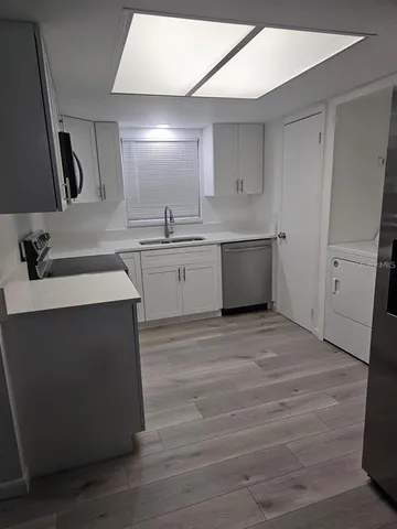 a room with a sink cabinets and wooden floor