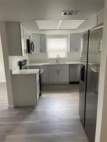 a kitchen with a sink refrigerator and microwave