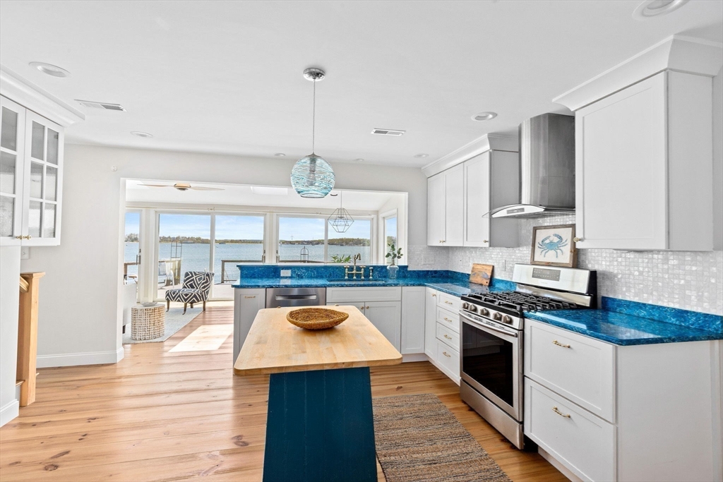 30 Lighthouse Road Scituate, MA 02066 - Photo 8 of 36 a kitchen with stainless steel appliances granite countertop a stove top oven a sink dishwasher and white cabinets with wooden floor