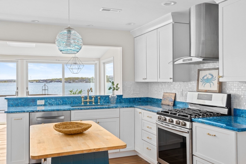 30 Lighthouse Road Scituate, MA 02066 - Photo 9 of 36 a kitchen with stainless steel appliances granite countertop a sink a stove and a wooden floors