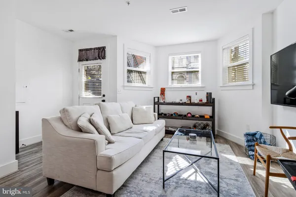 a living room with furniture a flat screen tv and windows