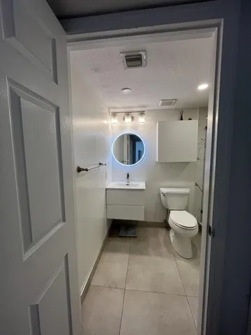 a bathroom with a toilet a sink and a mirror