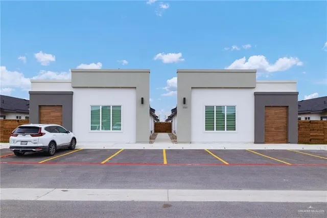 a front view of a house with a parking space