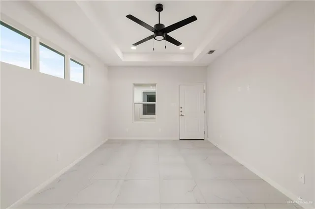 an empty room with a window and a ceiling fan