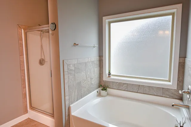 a white bath tub sitting next to a shower