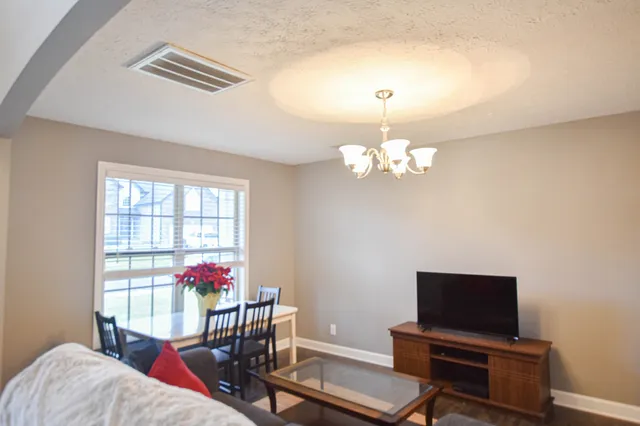 a living room with furniture a piano and a window
