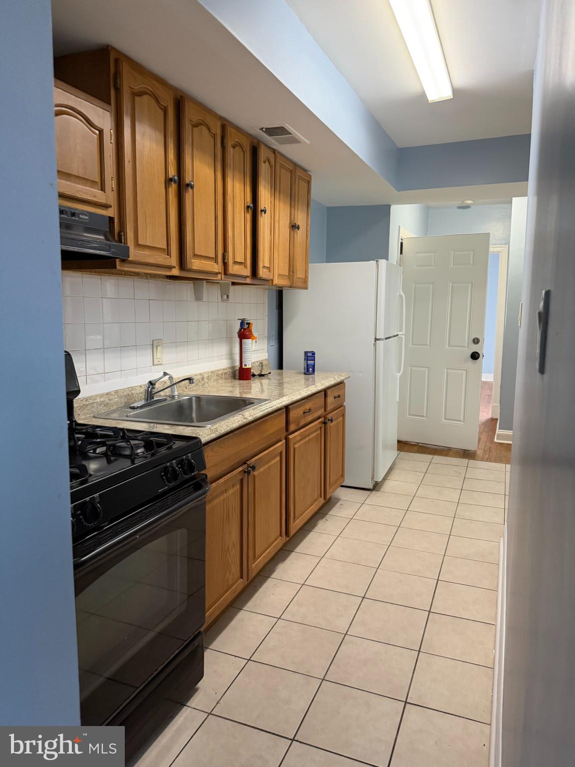 5119 2nd Street Northwest, Unit 4 Washington, DC 20011 - Photo 6 of 6 a kitchen with stainless steel appliances granite countertop a stove and a refrigerator