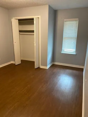 an empty room with windows and closet