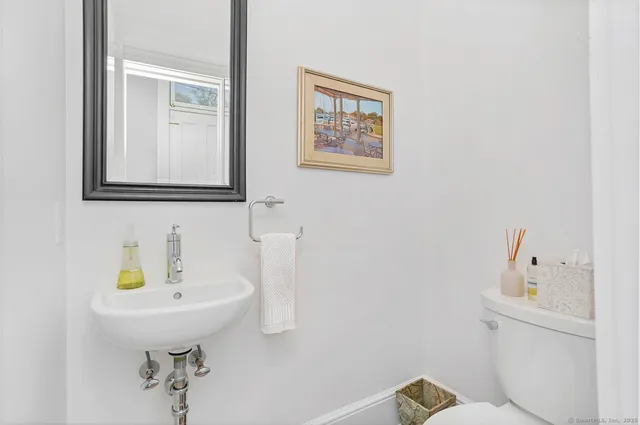 a bathroom with a sink a toilet and mirror