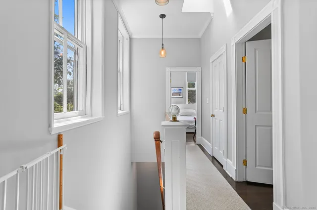 a view of a hallway with wooden floor and staircase