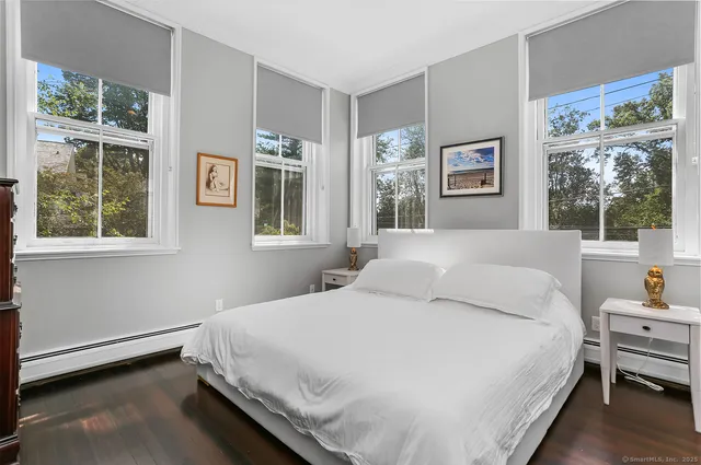 a bedroom with a bed wooden floor and window